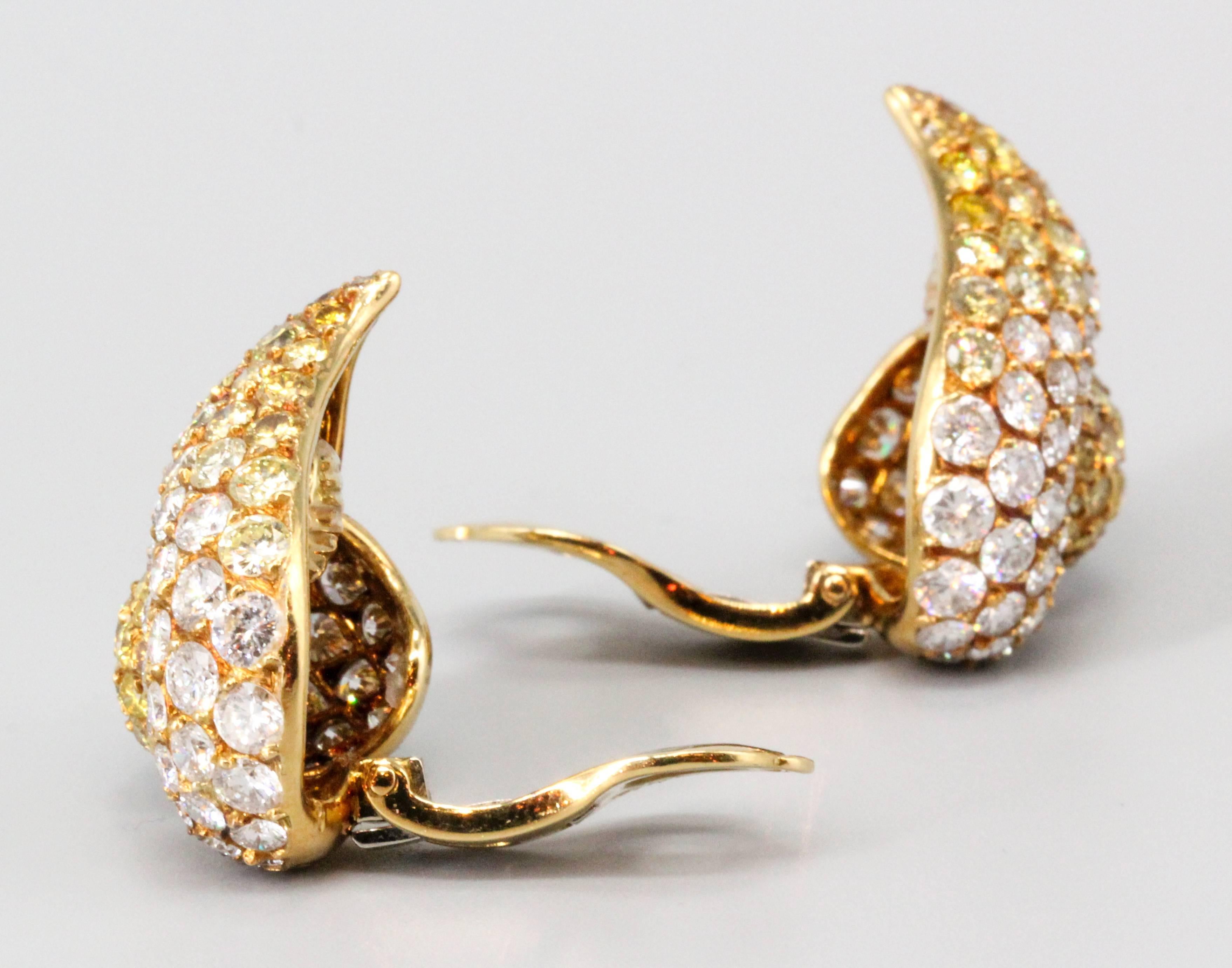 Very fine yellow and white diamond earrings set in 18K yellow gold by Gioia. The earrings are of abstract design, and feature approx. 10.0cts of high grade round brilliant cut diamonds of white and natural fancy yellow color. They show exceptional