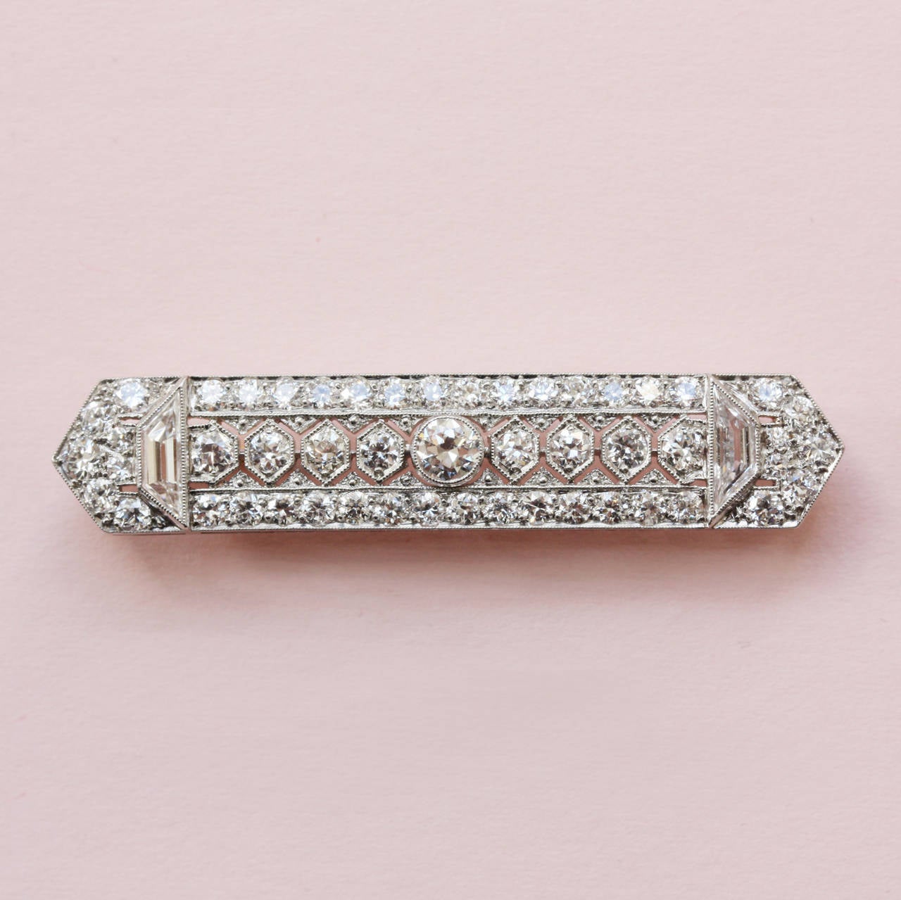 A platinum bar brooch set with brillant cut diamonds and two trapezium cut diamonds (in total app. 3.6 carats), with a gold pin, signed: Tiffany & Co.
U.S.A., circa 1915.

weight: 8.6 gram
dimensions: 4.8 x 9.5 cm.