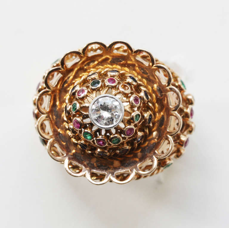 An 18 carat gold dress ring with cage work set with 18 sapphires, 10 rubies, 10 emeralds and in the centre a brilliant cut diamond set in platinum, possibly Belgium, circa 1955.

weight: 12.5 gram
ring size: 17 mm. 6 1/2 US.