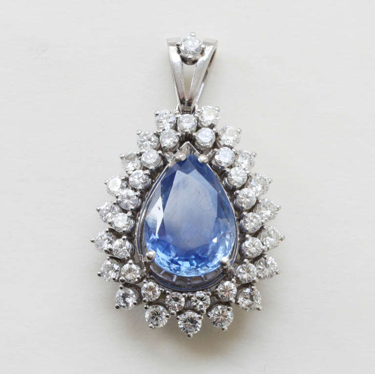 A white 18 carat gold pendant set with a large natural unenhanced pear shaped Ceylon sapphire (circa 10 carats) surrounded by old cut diamonds (circa 1.7 carats), circa 1950.

weight: 10.6 grams
dimensions pendant: 3 x 2 cm.
dimensions sapphire: