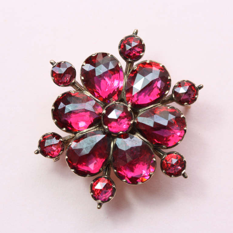 An 18 carat gold flower or snowcrystal brooch set with the prettiest brighest rose cut pyrope garnets, France, 19th century.

weight: 5.6 grams
diameter: 3.2 cm.