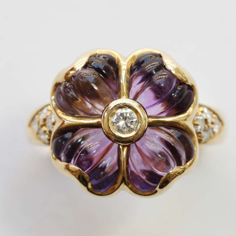 An 18 carat gold ring in the shape of a flower with birlliant cut diamonds in the shank and at the heart of the flower, the petals are carved amethysts, signed and numbered: Boucheron, France circa 1980.

weight: 8.2 grams
ring size: 16.75 mm. 6