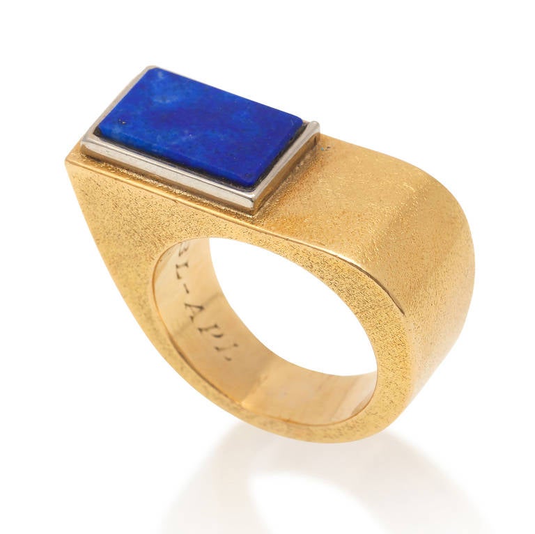 A big asymmetrical 18 carat etched gold and lapis - set in white gold - ring, signed and numbered: Cartier, 182 (with removable engraving: RBL-APL), circa 1970.

weight: 15.80 gram
ring size: 17.25 mm. 7 US.
dimension top view: 2.5 x 1.2