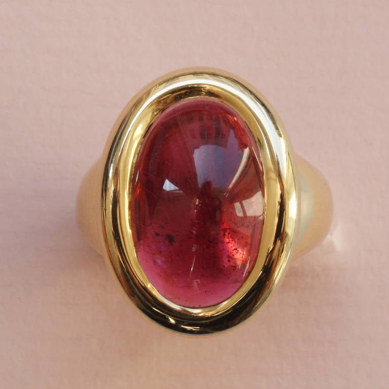 An 18 carat gold ring set with an oval cabochon cut pink tourmaline, signed and numbered: Cartier, C44660, France, circa 1990, model: 