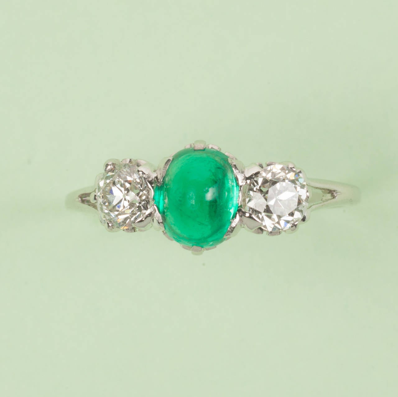 A platinum ring set with a high oval cabochon cut emerald with on each side an old cut diamond (app. 0.4 carat in total), signed: Tiffany & Co., US, circa 1910.

ring size: 15.75 mm. 5 US.
weight: 2.7 grams