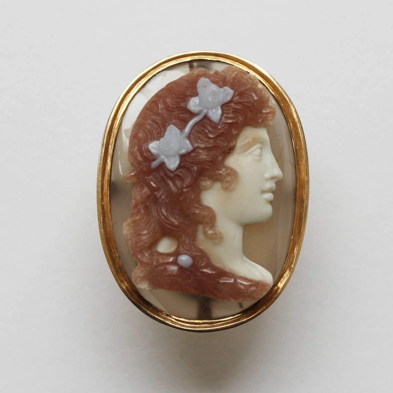 An early 19th century four layered agate cameo of the goddess Flora with flowers in her hair in a later 18 carat gold mounting.

weigth 11.3 grams
dimensions cameo: 2.6 x 1.6 cm.
ring size: 17 mm. 6.5 US