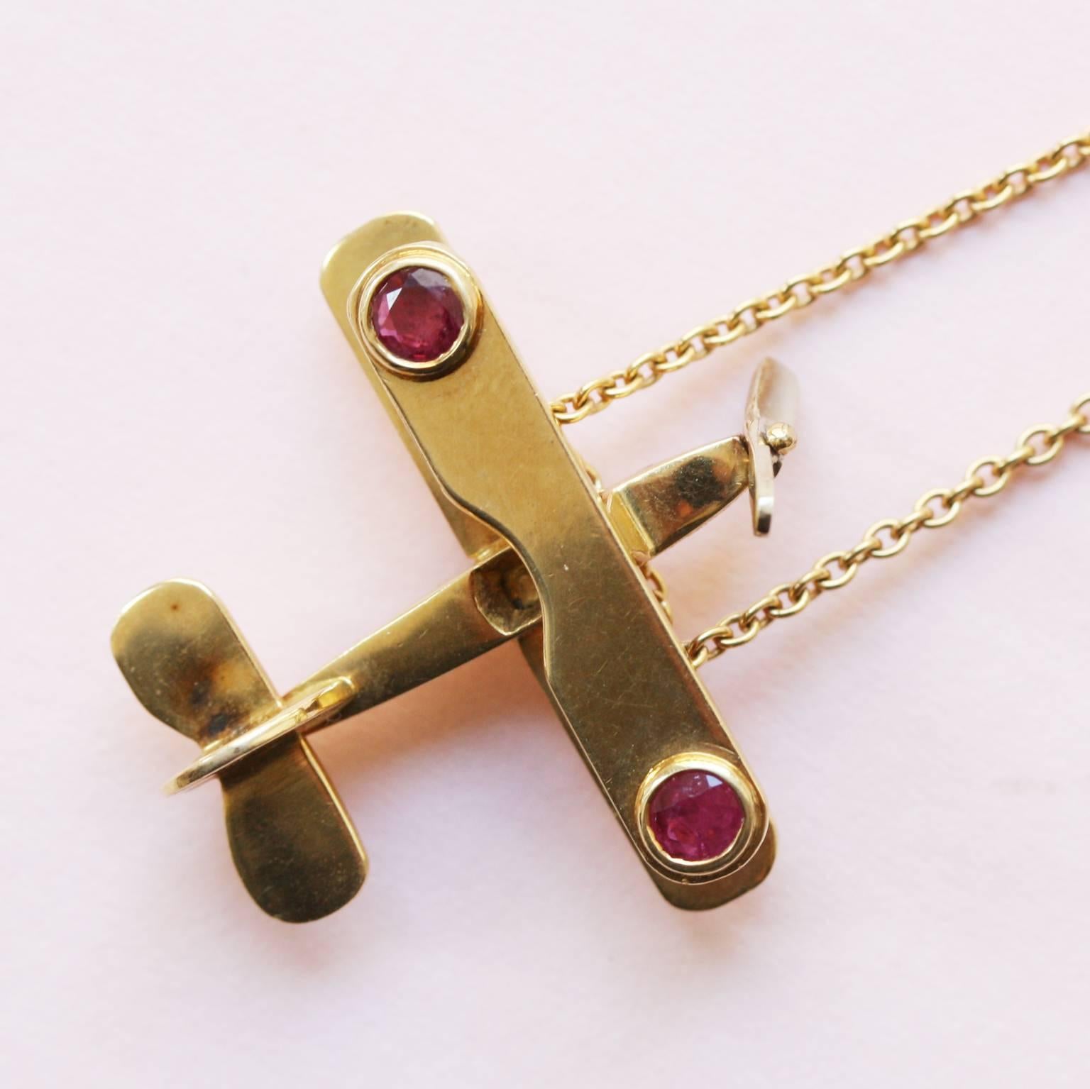 Ruby and yellow 18 carat gold double decker plane pendant with white gold moving propellor, signed: Fred of Paris. 

weight: 8.5 grams 
dimensions pendant: 2.6 x 2.4 cm. 
length chain: 40 cm