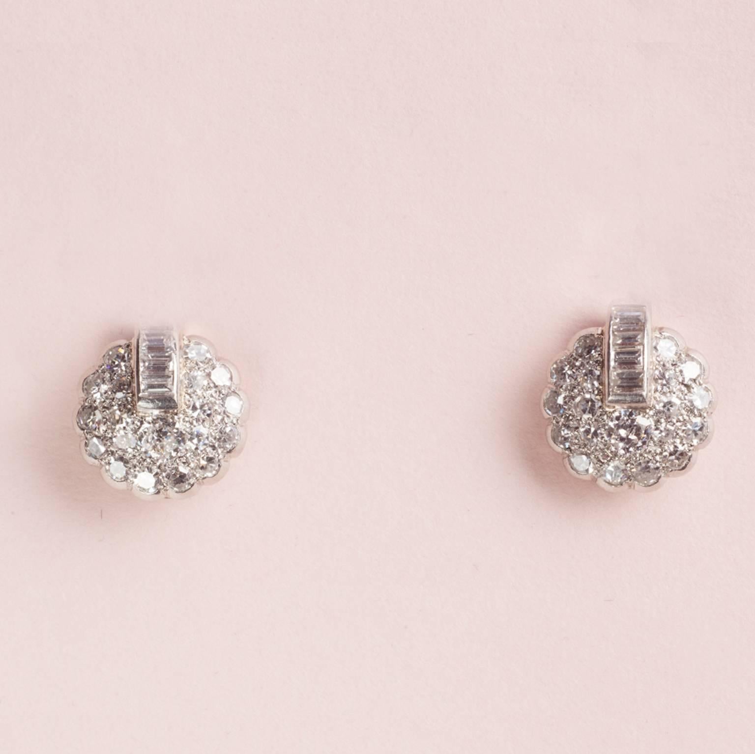 A pair of Art Deco earclips set with old cut and baguette cut diamonds (app. 1.12 carat), England, circa 1930, in blue case.

weight: 5 grams
diameter: 9 mm.