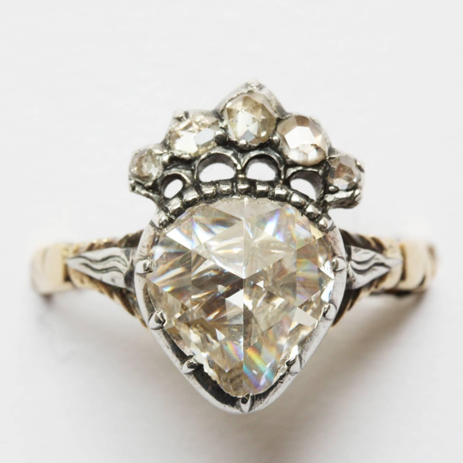 Ein Ring aus 14-karätigem Gold. Der zentrale, große, herzförmige Diamant im Rosenschliff (ca. 1,2 Karat, der das Aussehen eines Steins von mehr als 2 Karat hat) ist mit Silberfolie überzogen und in Silber gefasst. Gekrönt wird er von fünf kleineren