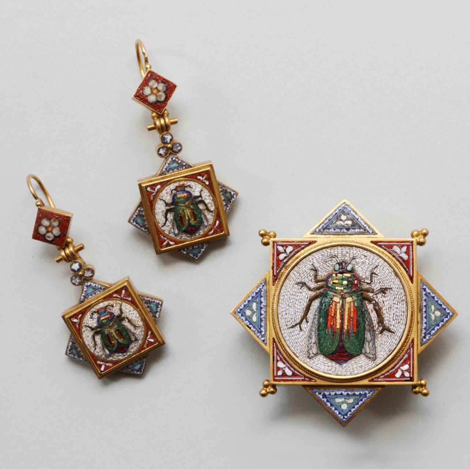 An 18 carat gold micromosaic Egyptian Revival suite consisting of a brooch and a pair of earrings, the micromosaics are decorated with beetles with little gold accented 'tesserae' the gold has applied wirework and beads and Papal marks for Italy