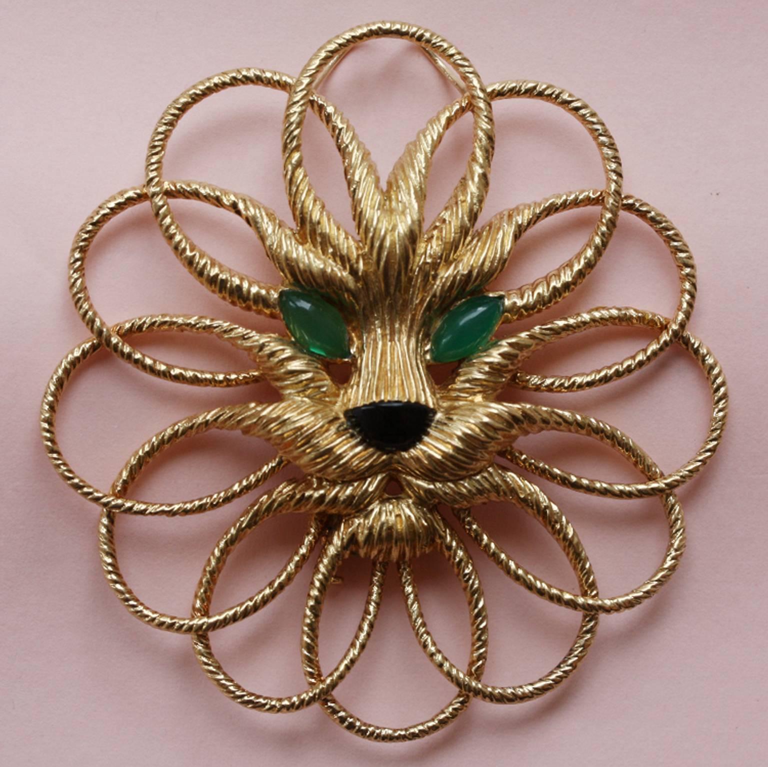 A marvelous 18 carat gold lion brooch (and pendant). Its whiskers and manes are designed in circles of textured gold that go around his face, with an onyx nose and chrysoprase eyes, on a 18 carat gold long chain, both signed and numbered: Van Cleef