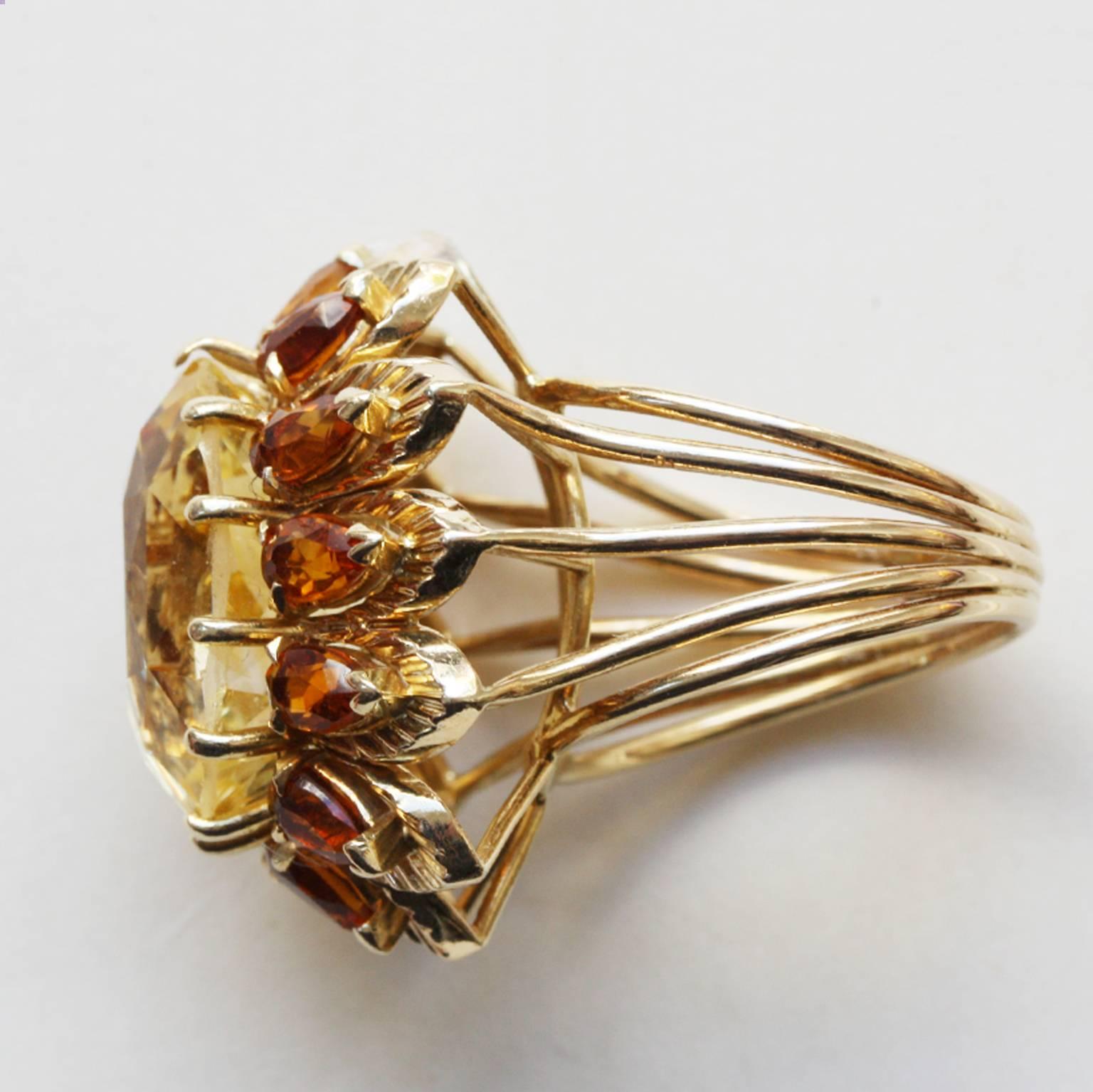 An 18-carat gold cocktail ring set with an oval-cut yellow natural Ceylon sapphire (app. 14 carats) surrounded by 12 pear-cut citrines, circa 1960.

ring size: 16.75 mm / 6 ¼ US
weight: 13.7 grams
dimensions sapphire: 16.9 x 12.4 cm