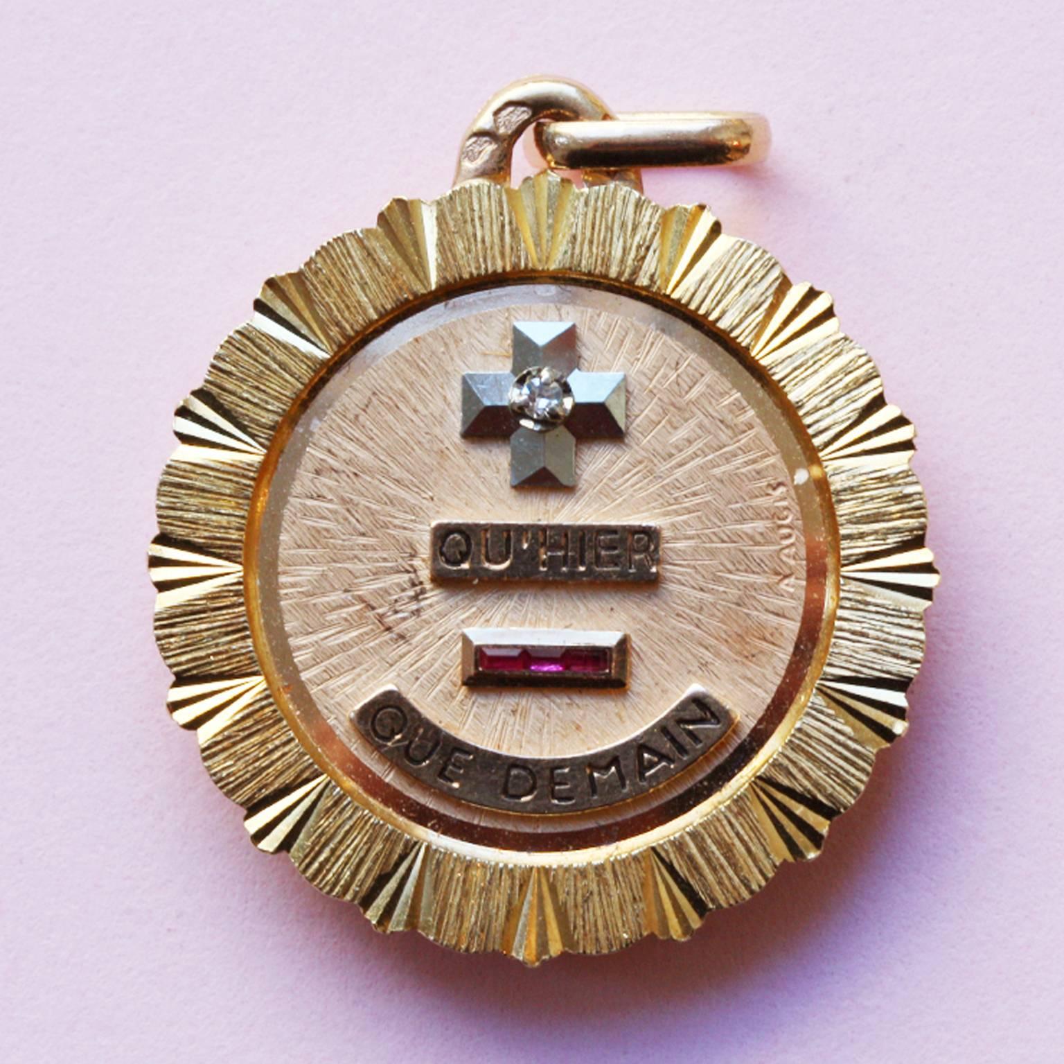 An 18 carat gold charm and locket with the text 