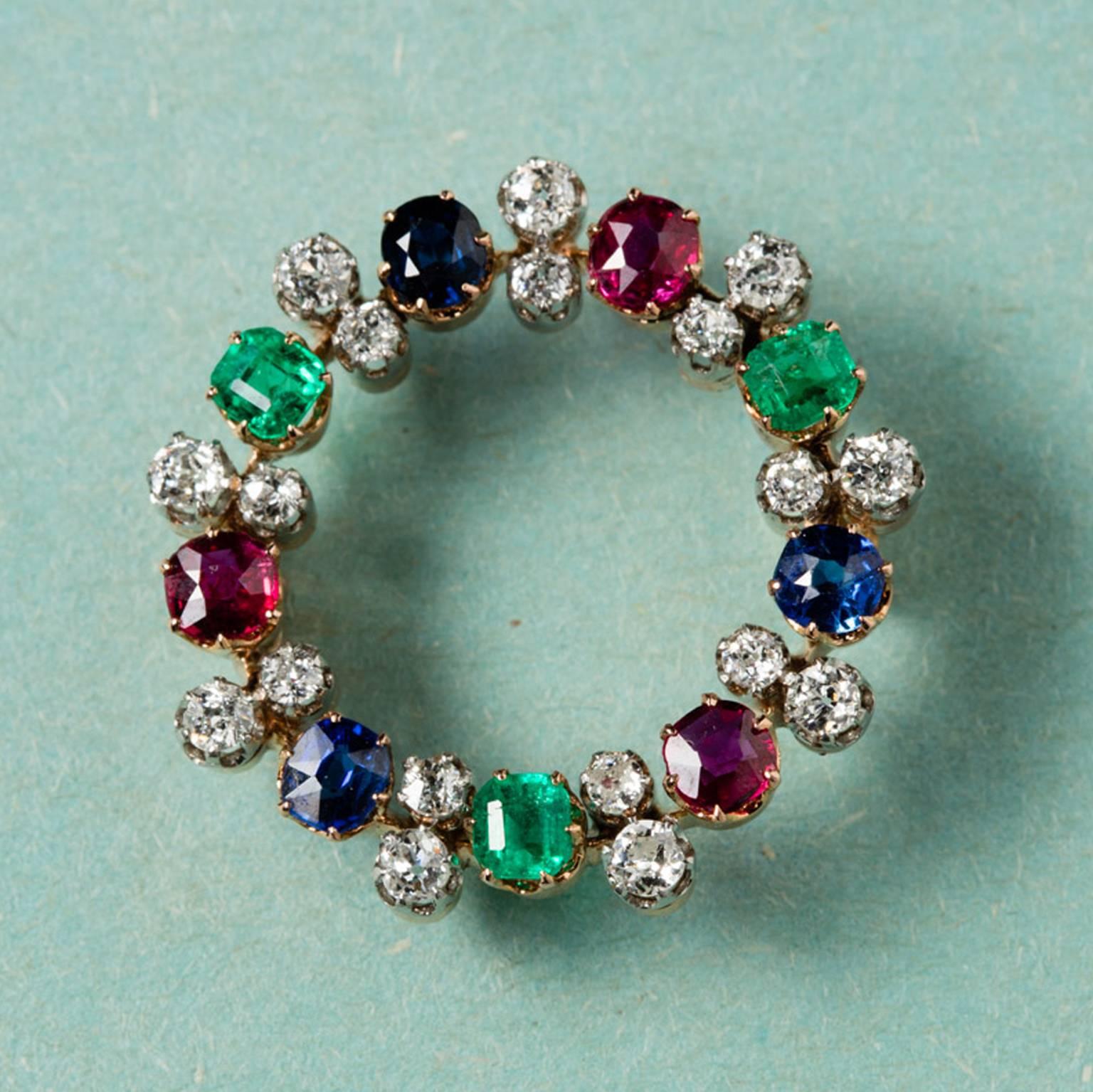 A gold circle brooch set with oval cut sapphires, rubies, emeralds and in between each stone 2 old cut diamonds, numbered: 13255 circa 1910.

weight: 8 grams
diameter: 2.7 cm