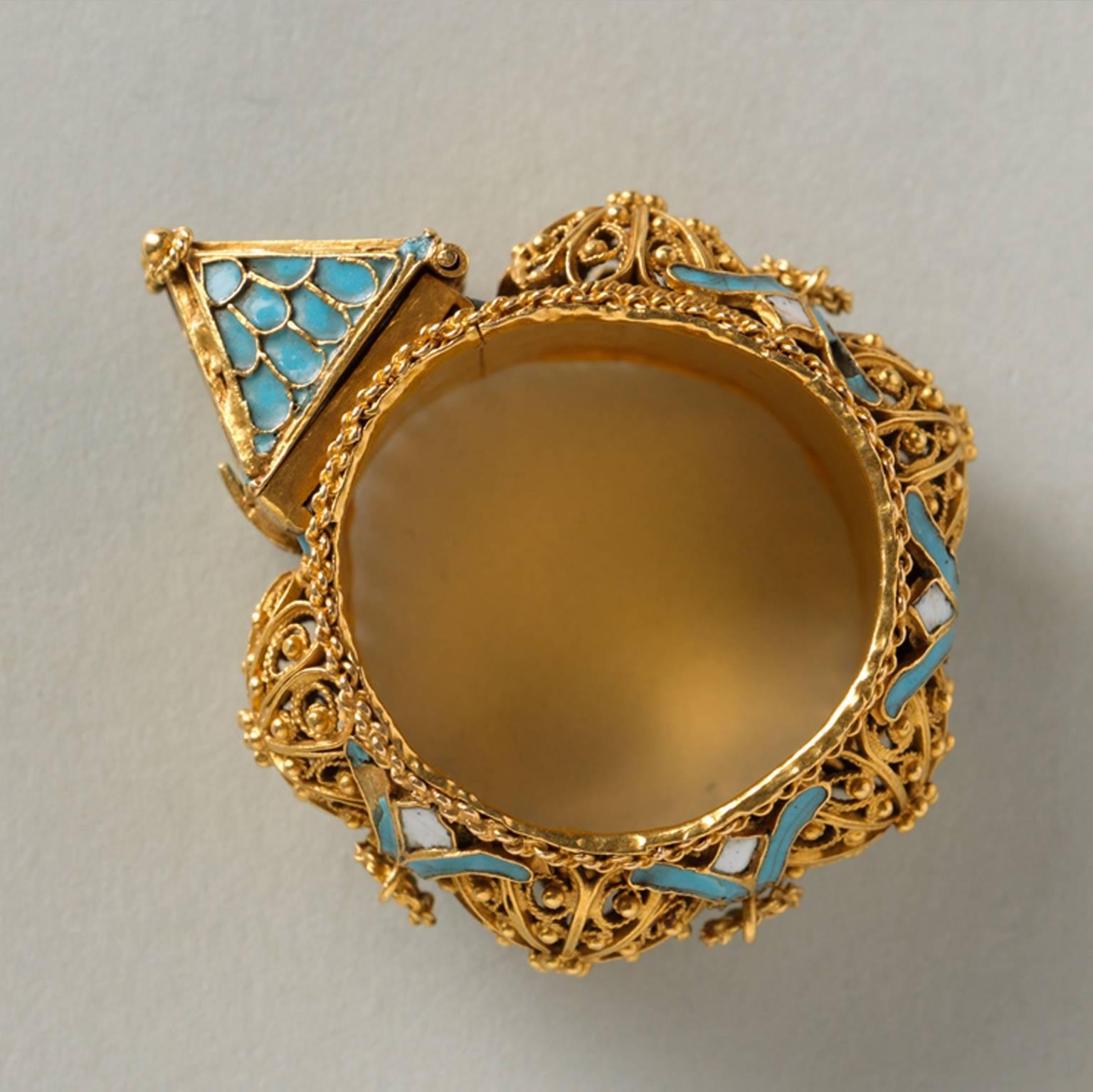An important Jewish-marriage ring; hoop large and broad gold band, with filigree bosses enriched with little flowers in between, on which are loops of twisted gold wire (one is missing); twisted wires along the edges and white and blue enamel; on