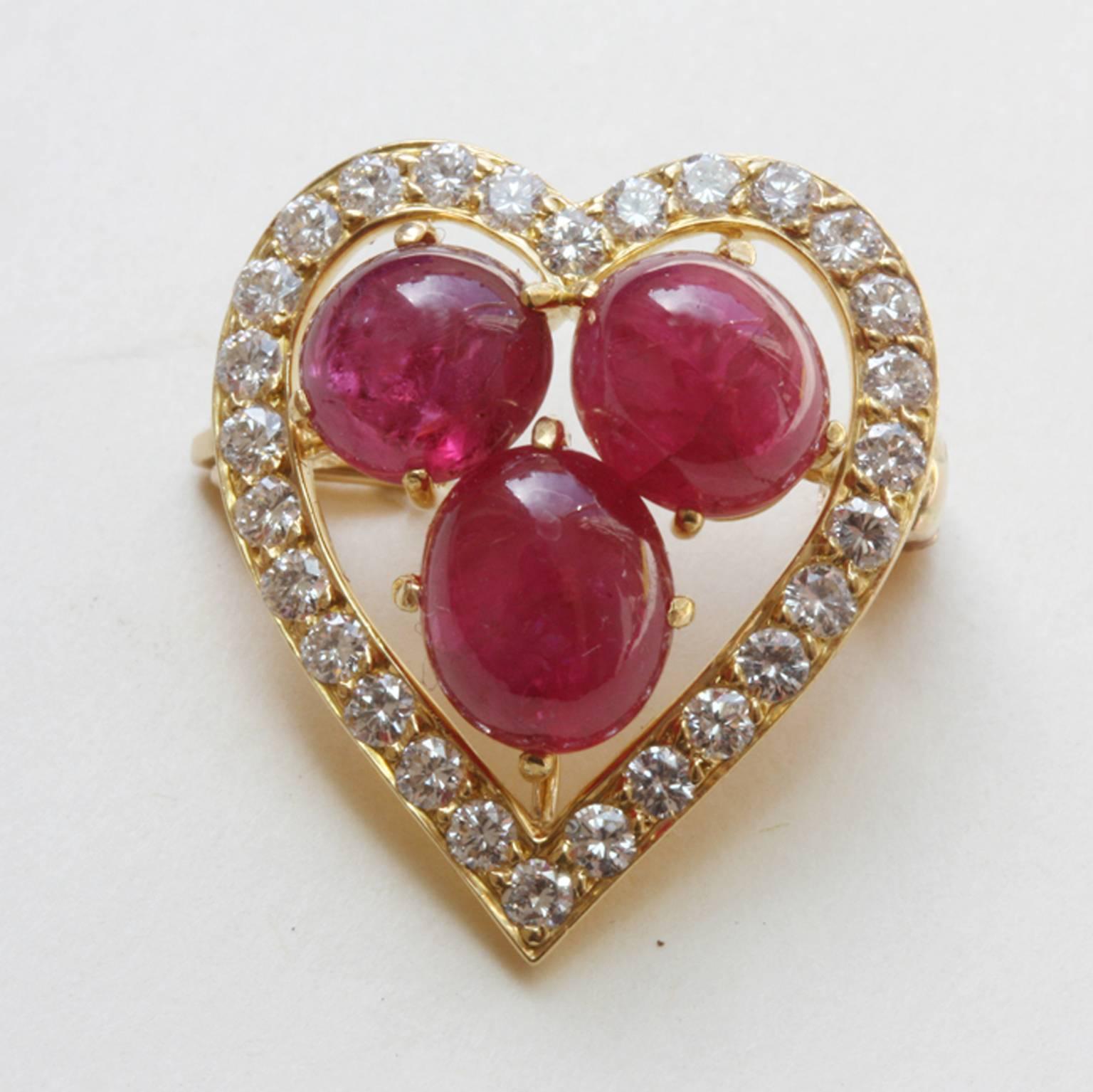 A sweet little 18 carat gold brooch in the shape of a heart, set with 28 brilliant cut diamonds (app. 0.56 in total, VS2, G-H) in the center three cabochon cut natural rubies (7 x 6 mm), signed and numbered: Cartier, Q4269.

weight: 4.3
