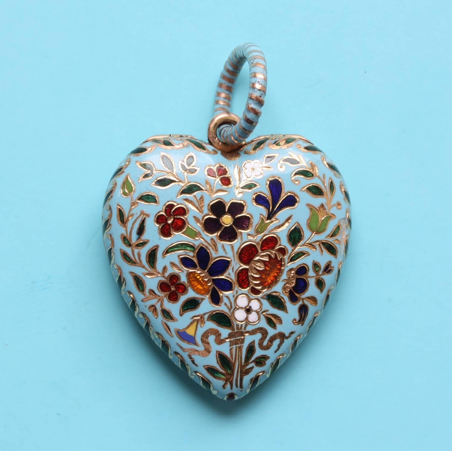 Aperfect 19 carat gold heart-shaped gold locket decorated with a colorful flower bouquet on a light blue background, a different bouquet on each side of the locket, suspending from a large hoop with a striped decoration in blue enamel and gold, the