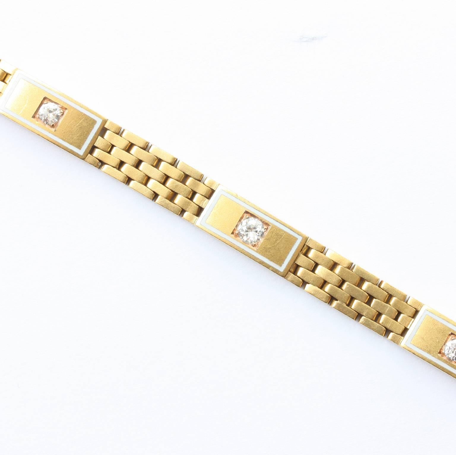 A 14 carat warm yellow gold bracelet with reactangular flat woven links featuring three rectangular elements each with a white enamel border and an old cut diamond (app. 0.35 carat in total), circa 1920.

weight: 20.52
dimensions: 18.7 x 0.6 cm.