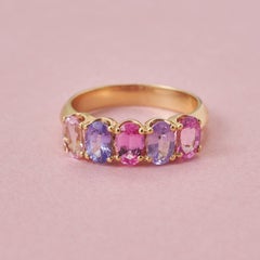 Un anello a fascia in oro 18 carati con 5 zaffiri rosa e viola