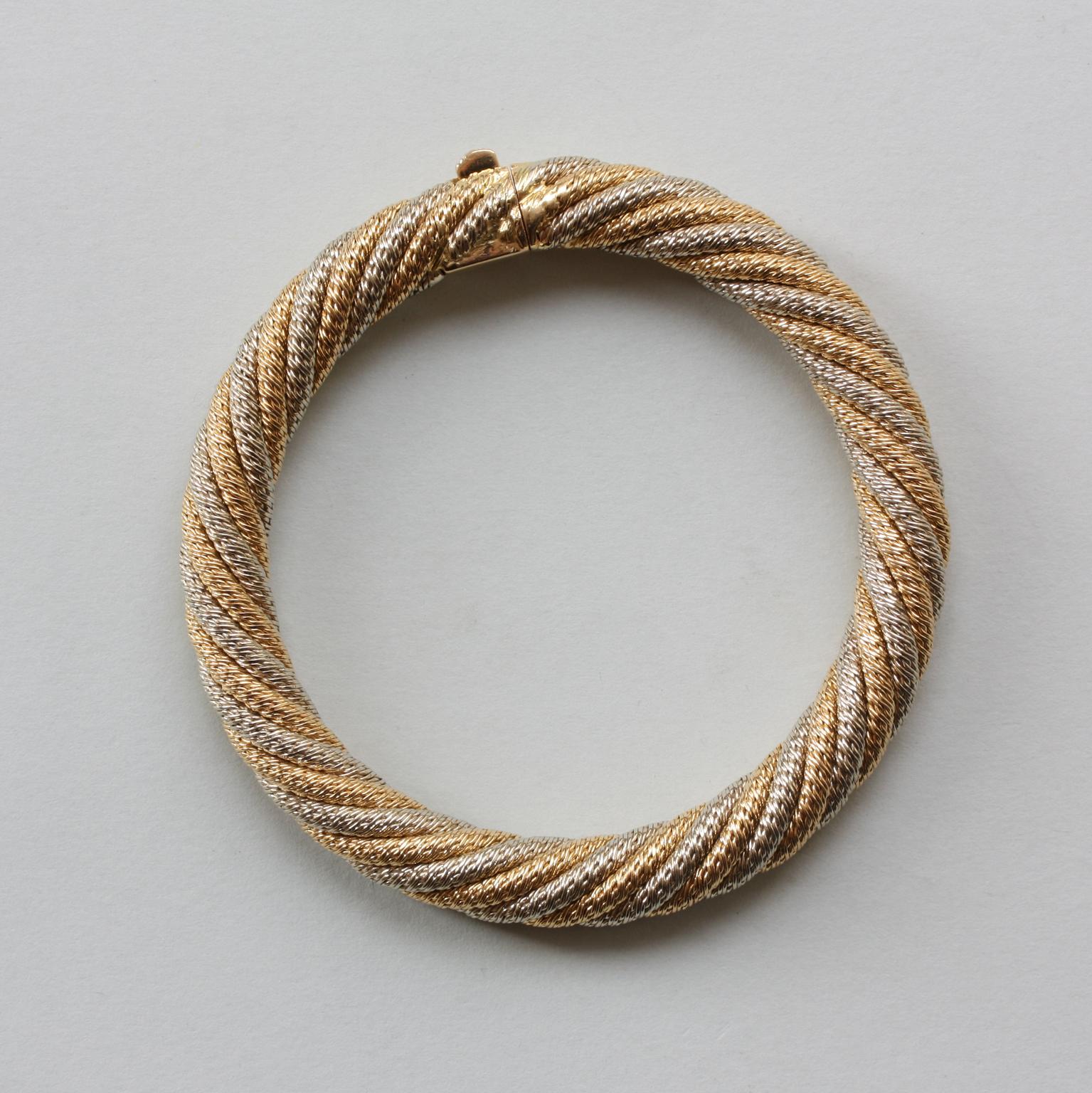 An 18-carat bi-colour gold woven bangle, with the two colours of gold intertwined. Cylindrical and flexible with a lock. Georges Lenfant, circa 1970.

weight: 61.42 grams
dimensions: 5.5 x 5.5
inner circumference: 17 – 17.5 cm
width: 9 mm
