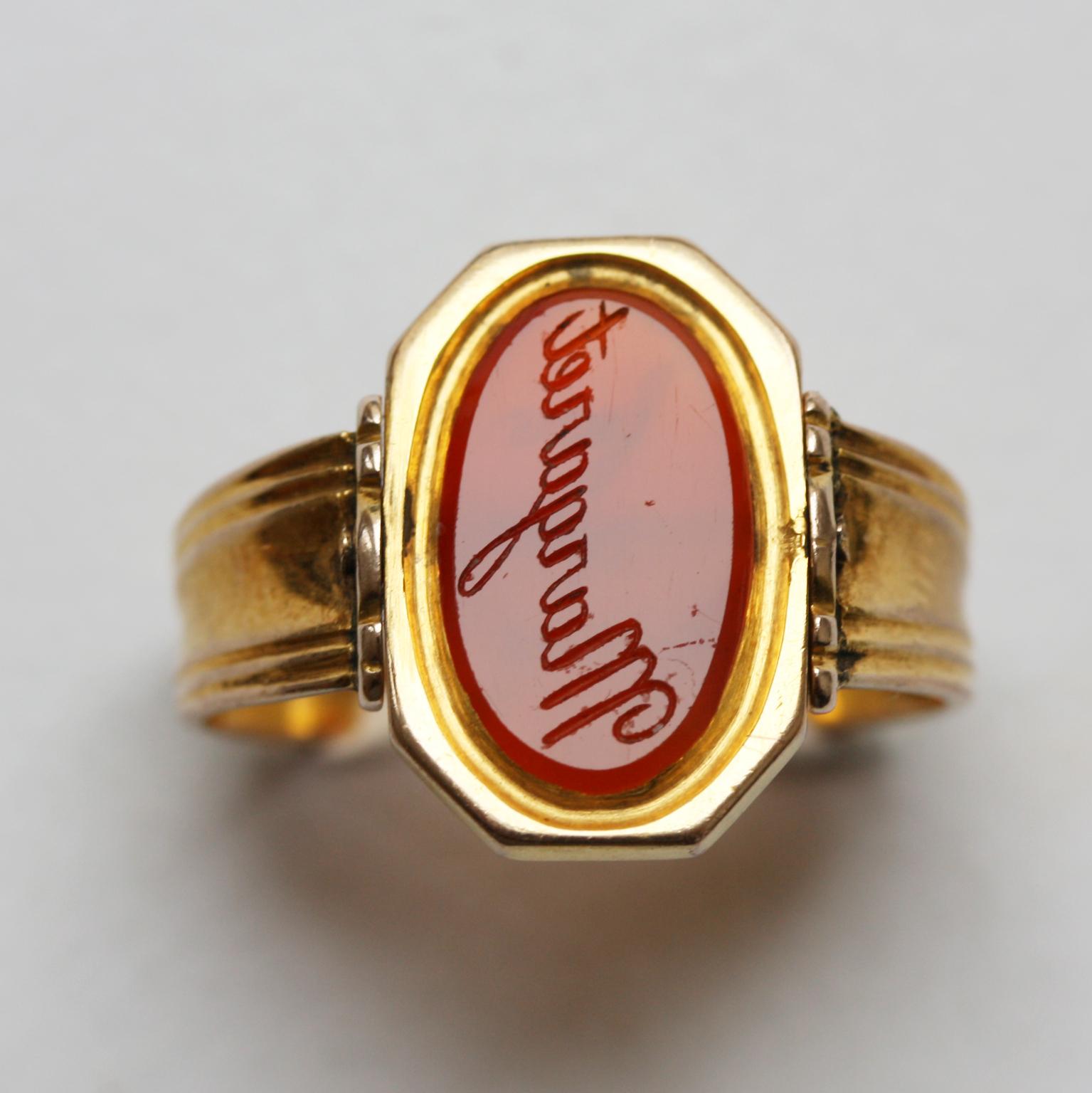 An 18 carat gold swivel ring with a flat oval carnelian, both sided engraved in reverse on one side with the name, Margaret and on the other side with the text “Crack without fear” which means that you should not be afraid to make a joke.

ring
