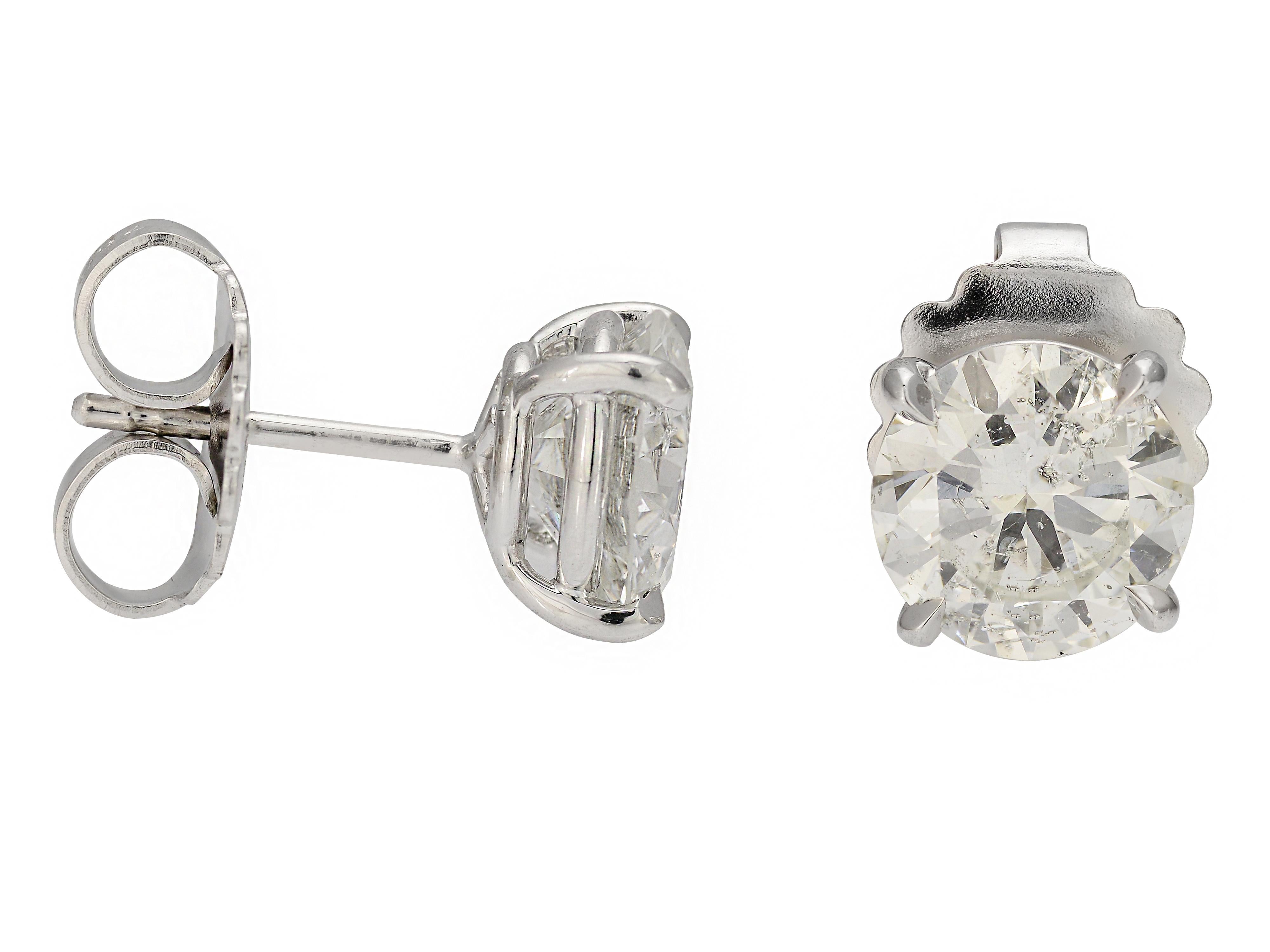 18 Karat White Gold Diamond Studs Featuring Two Round Brilliant GIA Graded Diamonds. The First Is 2.01 Carats I2 Clarity & I Color, And The Other Is 2.05 Carats I2 Clarity & G Color. The Diamonds Are Matched For Clarity, Diameter & Table Size. The 4