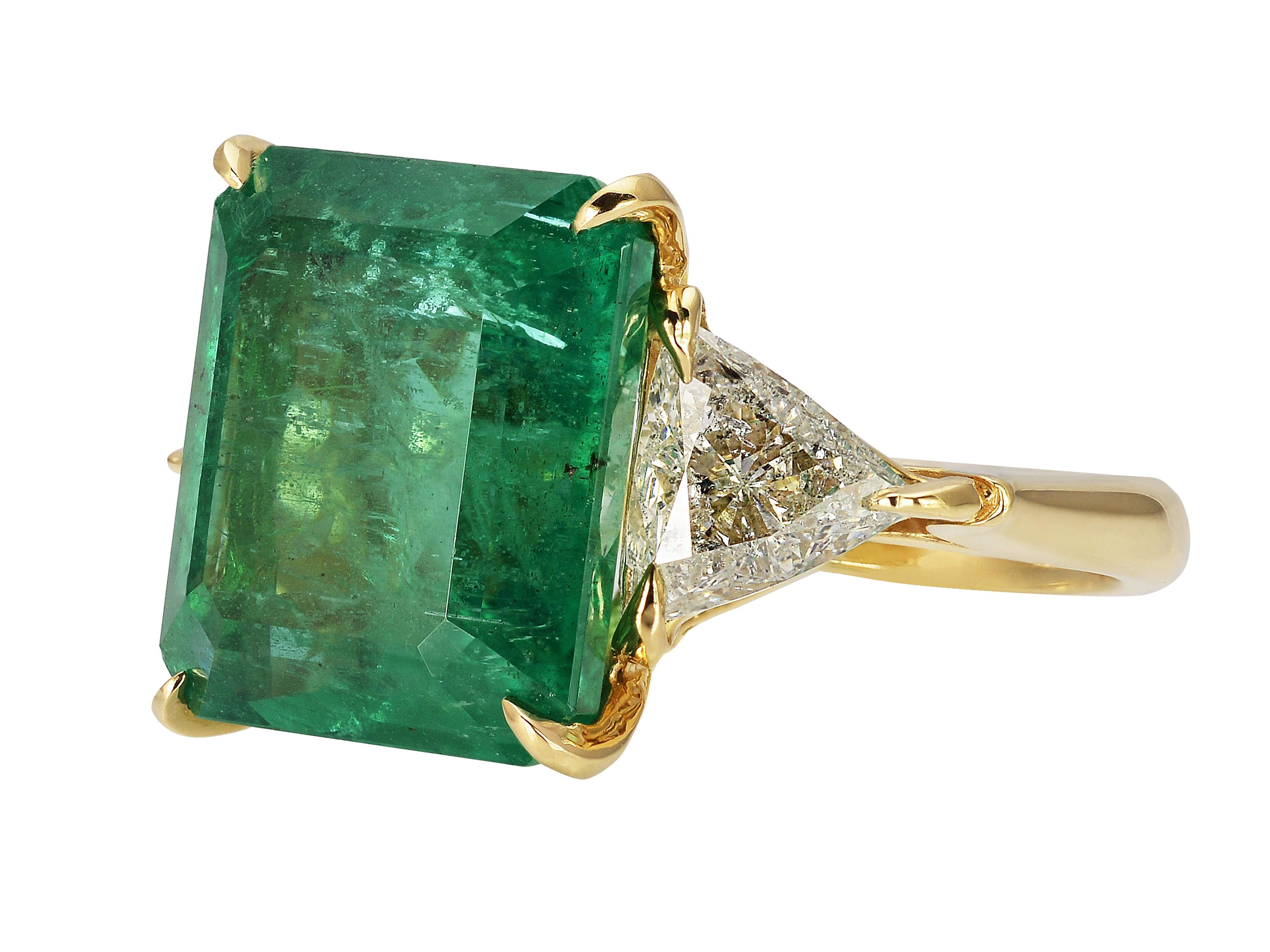 18 Karat Yellow Gold Three Stone Cocktail Ring Featuring A 10 Carat Emerald GIA Graded As Zambian In Origin. Two Trilliant Cut Side Diamonds Total 1.40 Carats Of I1 Clarity & H Color. Hidden Hearts in Gallery. Finger Size 6; Purchase Includes One