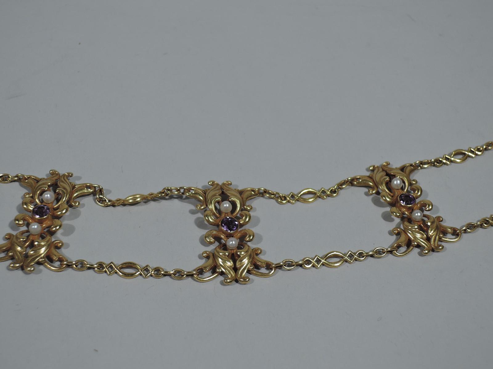 Art Nouveau 14k gold choker with amethysts and pearls. Eight leafy scroll partitions, each applied with two pearls and one amethyst. They are joined at top and bottom by intricate curvilinear chains. United States, ca 1900.