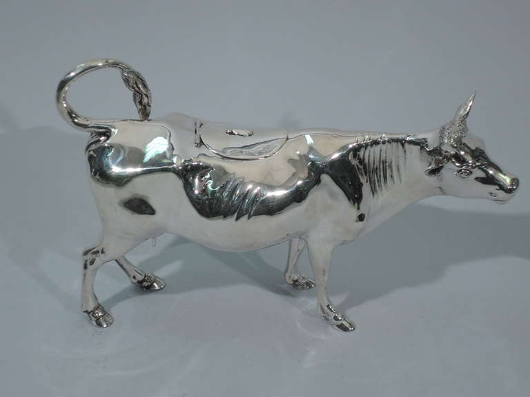 Large cow creamer in 800 silver. Made in Germany, ca. 1910. The jumbo version of the traditional bovine form: sturdy build with sharp horns, solidly planted hoofs, gaping mouth, and overall air of benignity. Tail flicked upwards to form ring handle.