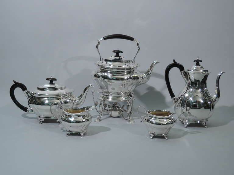 Edwardian sterling silver tea set. Made by Charles Stuart Harris in London in 1905-6. This set comprises 1 kettle on stand, 1 teapot, 1 coffeepot, 1 creamer, and 1 sugar.

Each: squat and tapering body with scrolled corner lobing. Four slipper