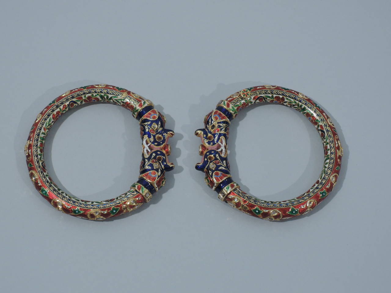 A spectacular pair of 22K gold and enamel elephant-head bangle bracelets decorated with deep red, blue, and green enamel and rose-cut diamonds. Made in Jaipur, India, ca. 1880. Provenance: formerly in the collection of the Maharani of Jaipur.