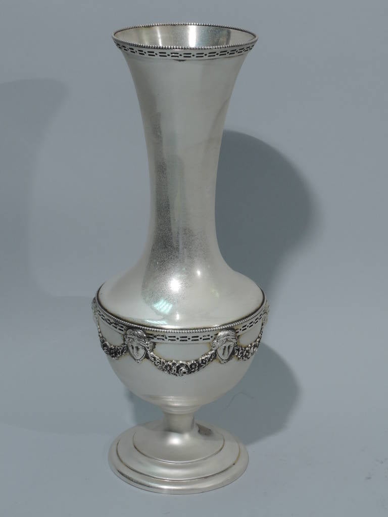 Sterling silver Neoclassical vase. Made by Theodore B. Starr in New York, ca. 1920. Baluster form with cylindrical neck and flared rim. Rests on stepped foot with short stem. Beading and pierced bands applied to rims. Body encircled with Classical