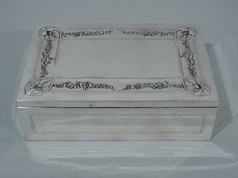 French 950 silver desk box, ca. 1910. Rectangular with paneled sides. Cover is hinged with molded rim. On top is rectangular cartouche bordered by garlands, scrolls, and foliage. Elegant and subdued. Art Nouveau with a hint of Rococo. Box and cover