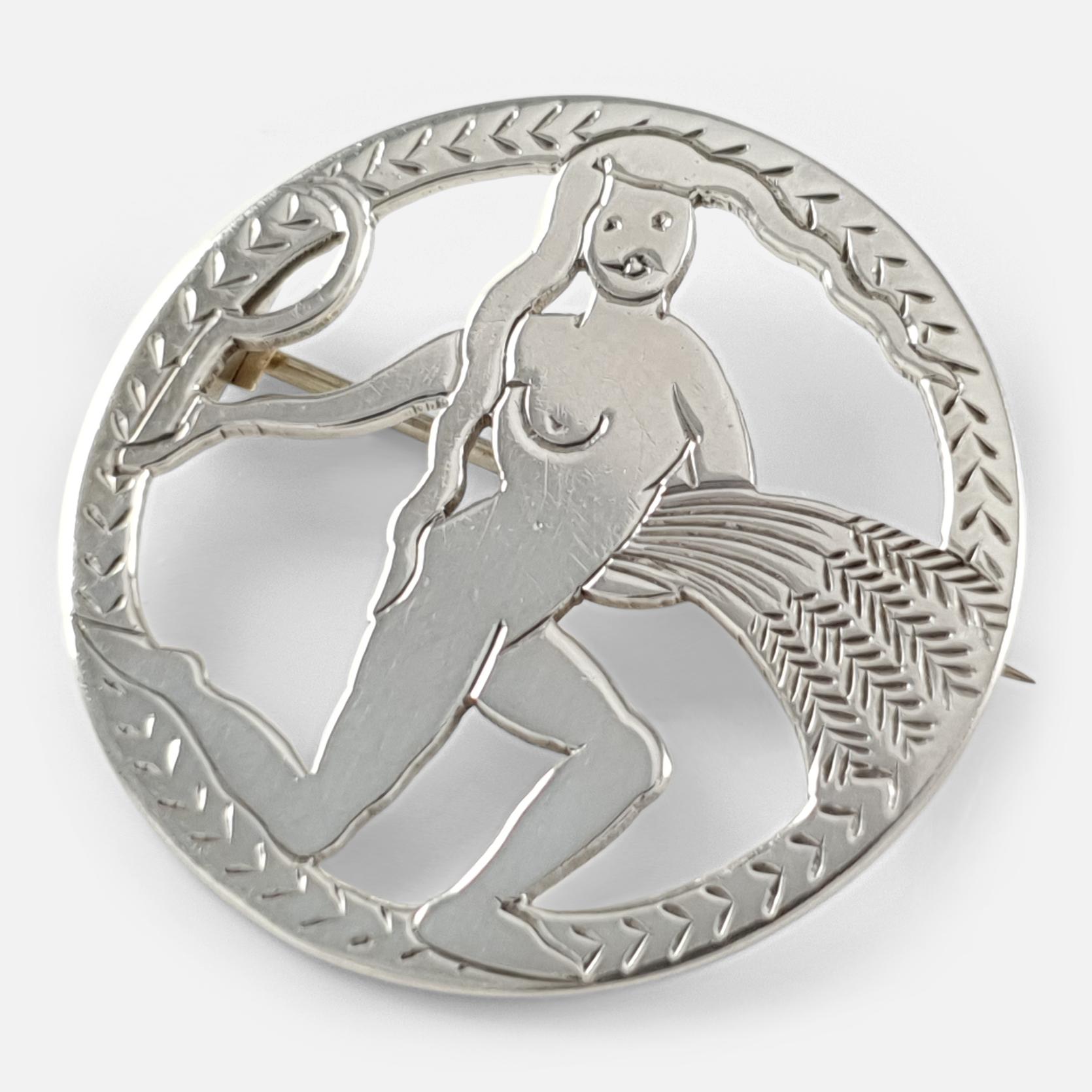 An Art Deco sterling silver brooch in the form of Virgo by H.G. Murphy. The brooch is stamped with London hallmarks for 1933, the Falcon Studio's mark, and the maker's mark HGM. 

Engraving: - None.

Measurement: - The brooch measures approximately