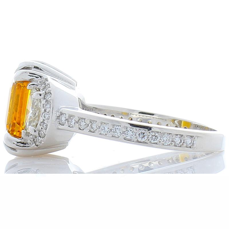 This fabulous yellow sapphire and diamond ring is nothing less than breathtaking! The design is exceptional, and the gemstones and diamonds are remarkably well matched. At the heart of this ring, you find a luscious and warm 3.55 carat emerald cut