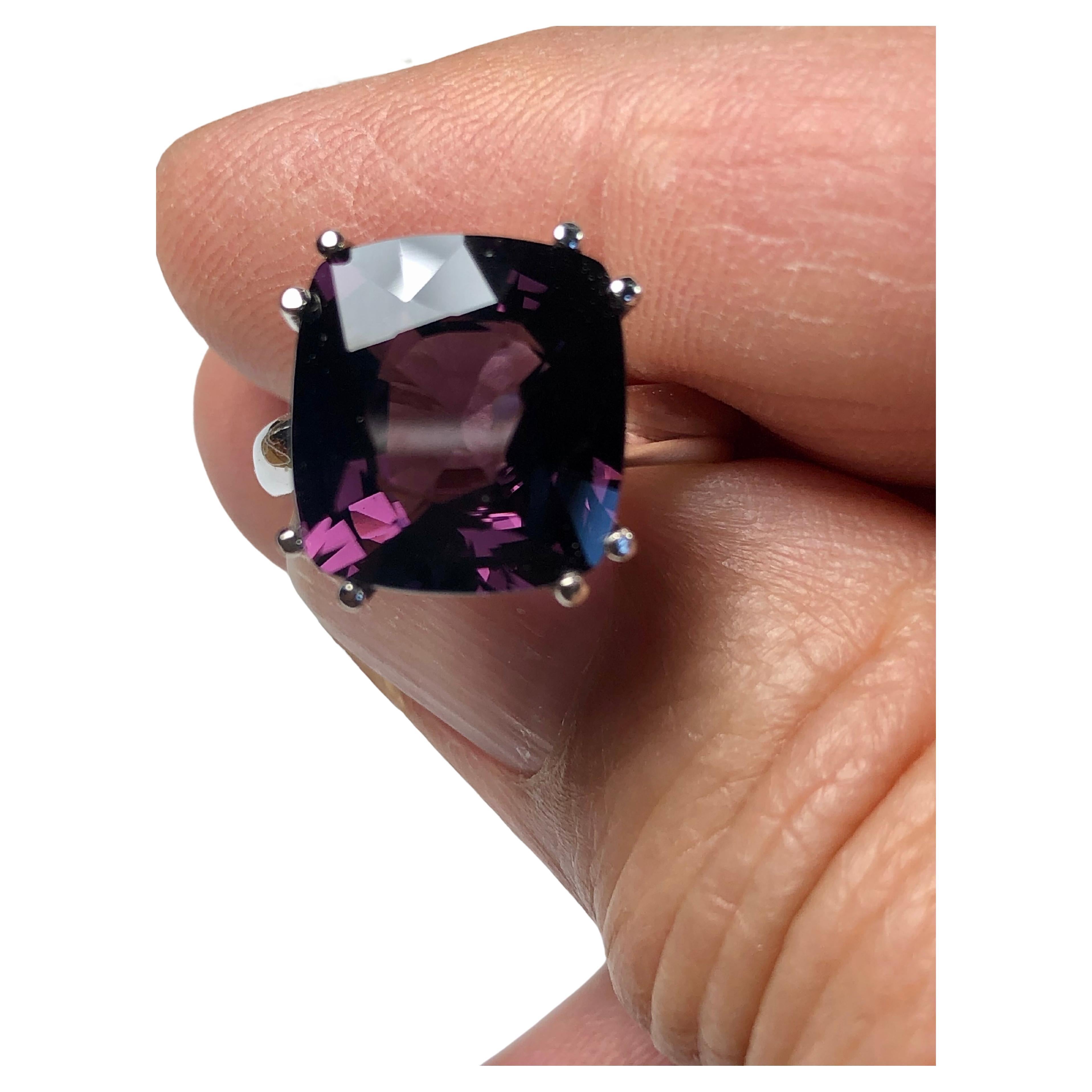 Deep grey mauve cushion cut spinel engagement solitaire ring. The gorgeous cushion cut spinel is set in an 18k solitaire white gold setting. The center natural untreated spinel is 8.22 carats. The gemstone is well-cut. The color is crispy and almost