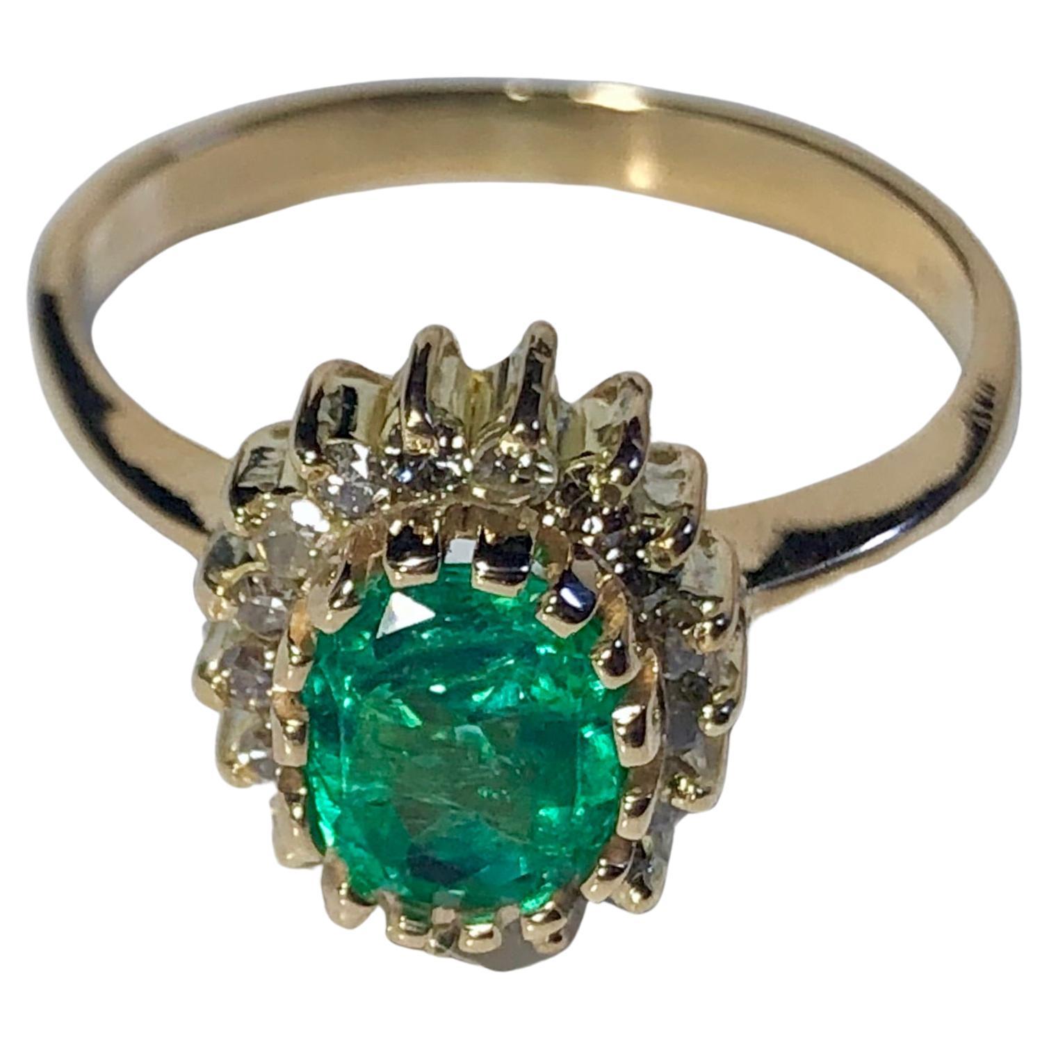 Cette bague de fiançailles Vintage Estate est sertie d'une émeraude naturelle de Colombie, de taille ovale, de couleur vert moyen et d'une très bonne clarté. Le poids total de l'émeraude est d'environ 1,30 carat. Accentué de diamants blancs ronds