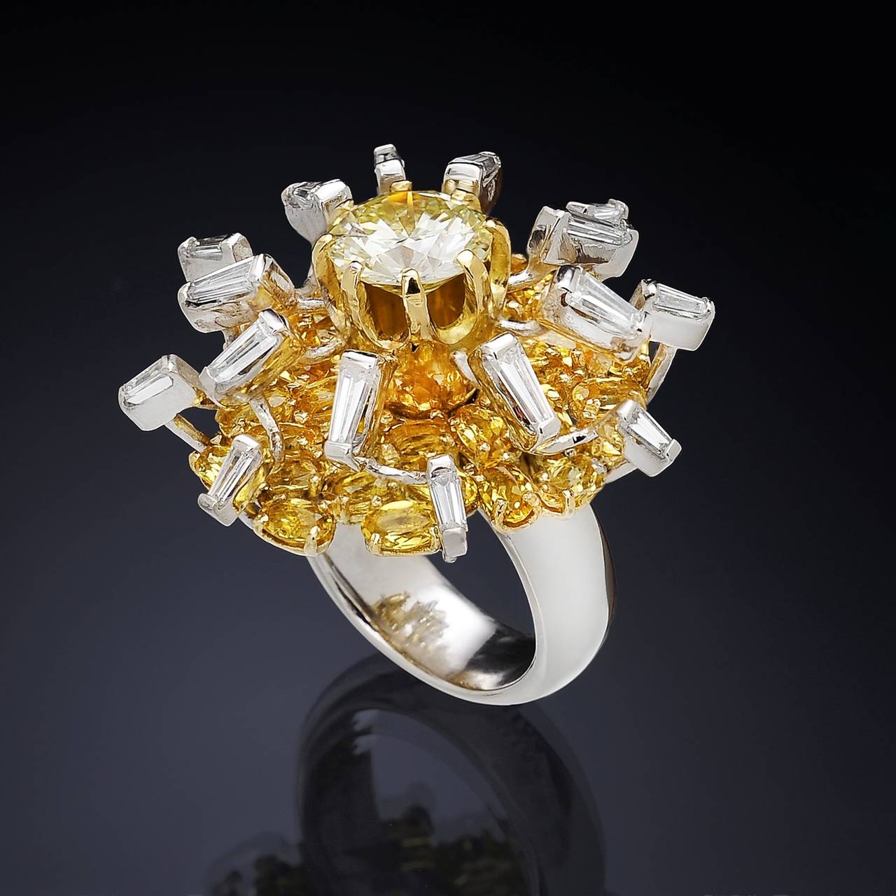 Gorgeous Big Bang cocktail ring inspired by the explosion, a perfect circle placed in the middle and lots of sparks around it, a large central diamond and trapezoid-cut diamonds set in white gold, represent the particles radiating outwards, while
