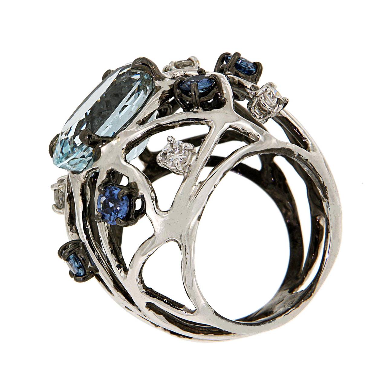 A surprising aquamarine is the main feature of this 18 karat white gold ring, sapphires and diamonds surround the precious stone. Modern ring, Air Collection, with aquamarine 5.70 ctw, brilliant cut diamonds 0.40 ctw and brilliant cut sapphires 1.40