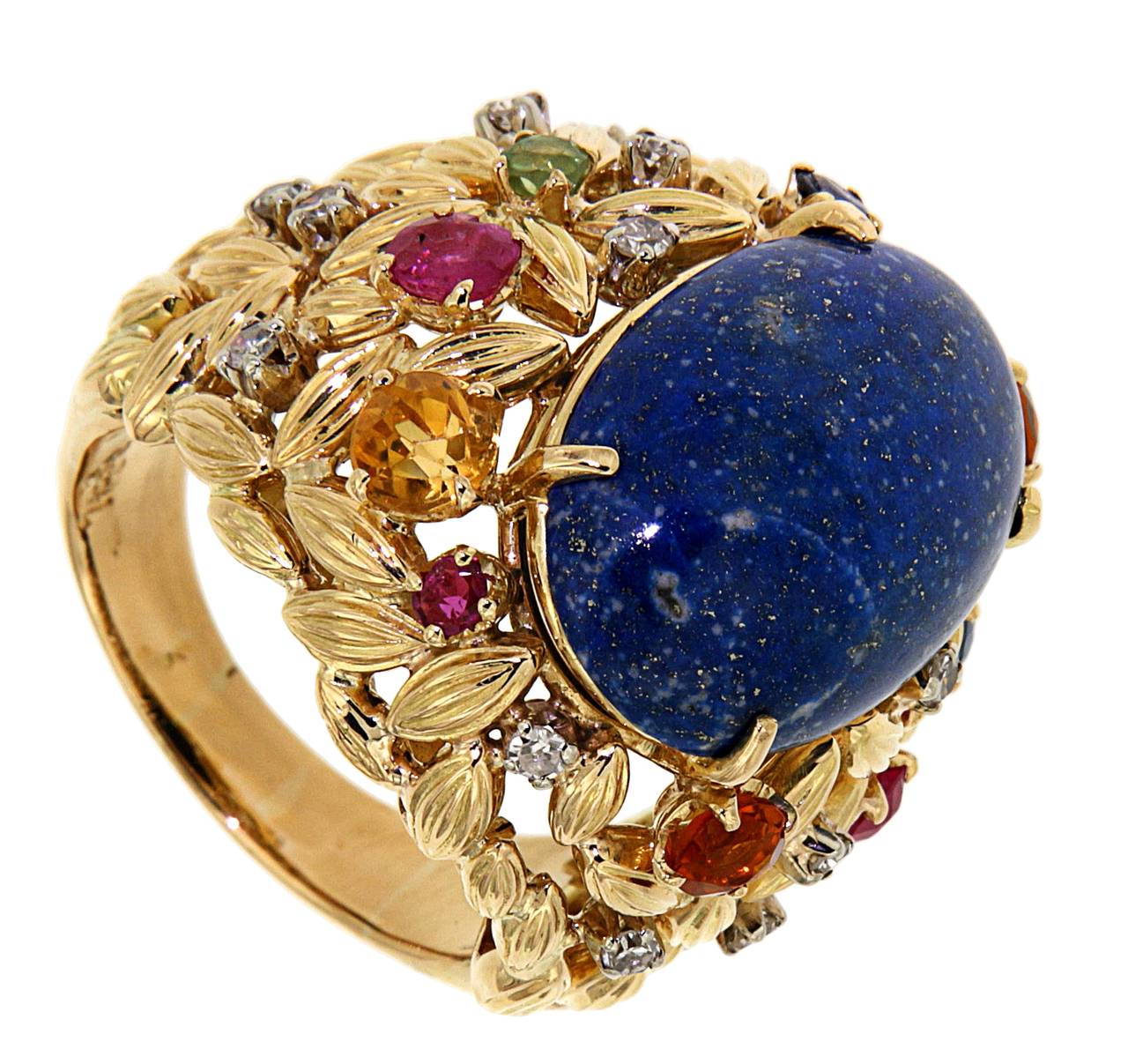 This vintage ring made in 1960s is crafted from 18 carat Yellow Gold Ring and an astonishing 20x13 mm Lapis Lazuli cabochon with 14 Diamonds of circa 0.14 carat, 3 Rubies, 2 Sapphires 3 Citrines.
The finger size is 6 3/4 but can be resized on