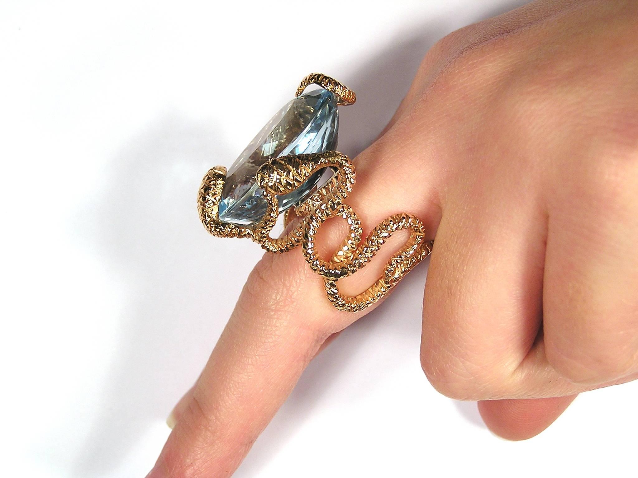 Modern snakes ring with natural blue topaz 48.20 ctw.
Topaz size is 27 x 19 millimeters / 1.06299 x 0.748031 inches.
Finger Size is 7.
This ring can be altered in size free of charg.
It  is stamped with the Italian Mark 750 - 716MI
Ready for