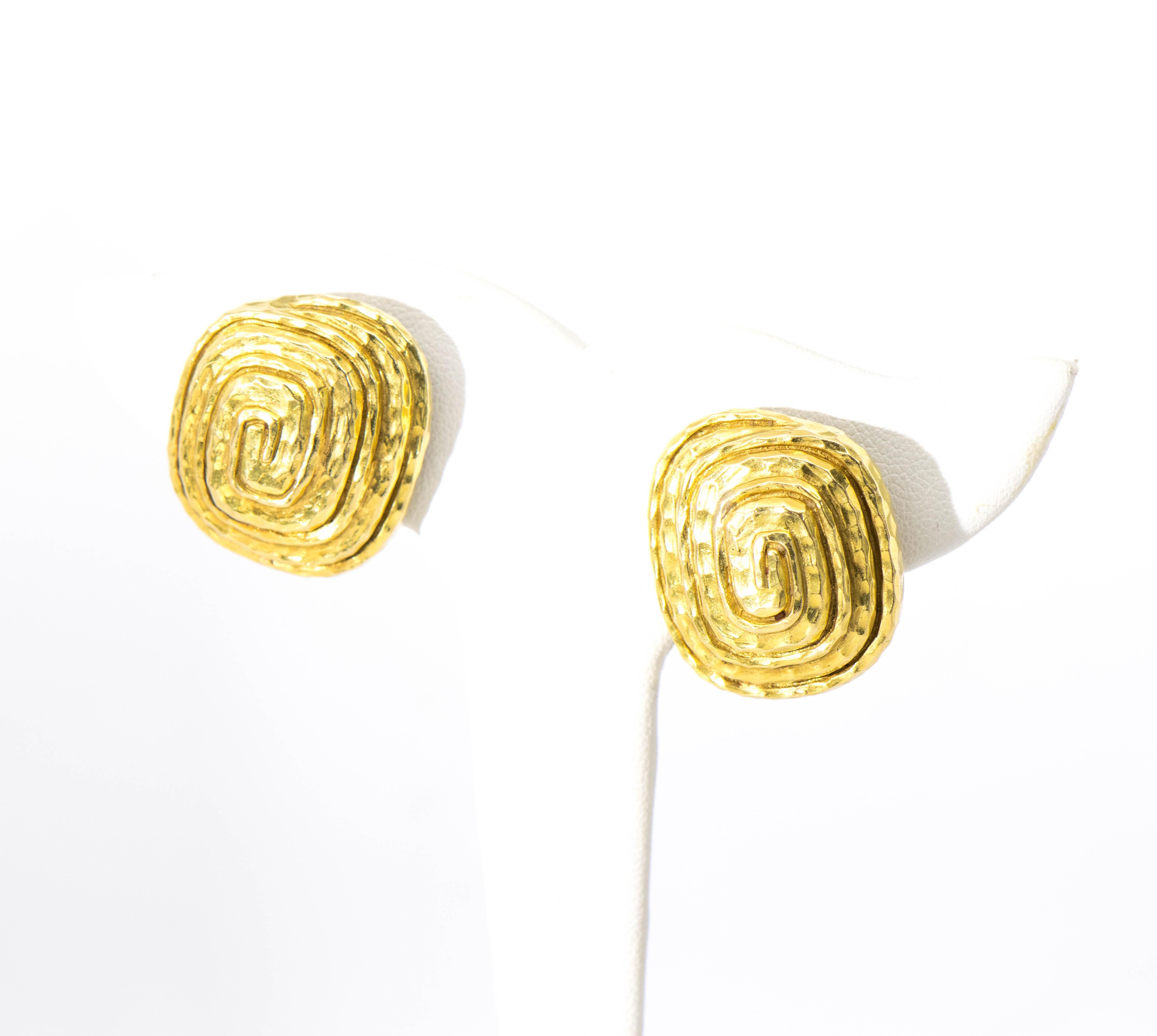 From the iconic Jewelry Designer David Webb, are these stunning Earrings. Fabricated in 18 Karat Yellow Gold in a hammered swirl along a rectangular shape with a clip back. The earrings are 1 1/4 inches in length and 1 inch in width with an