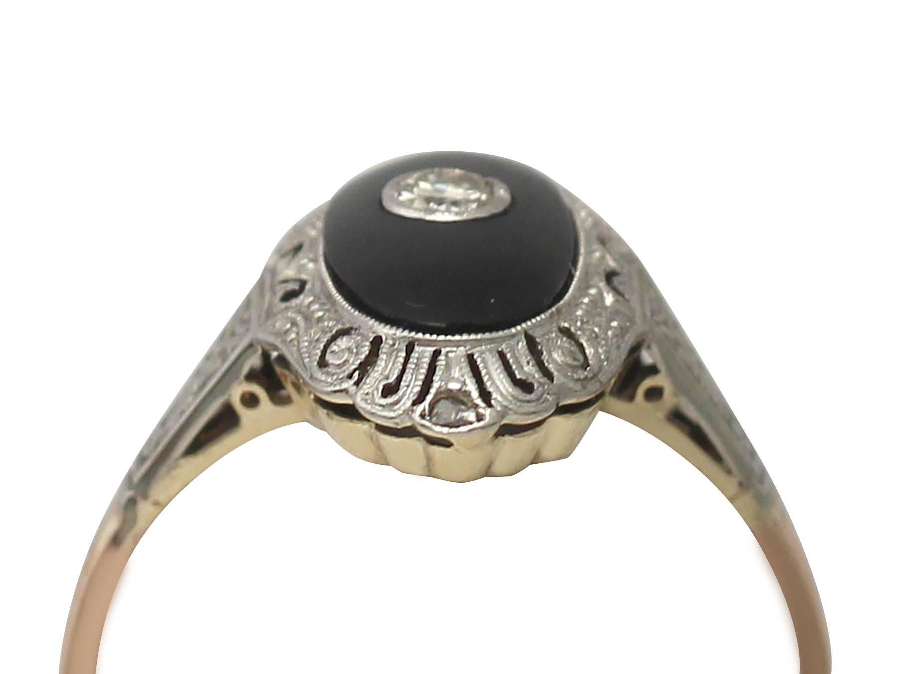 This fine and impressive black onyx and diamond ring has been crafted in 14k yellow gold, with a 14k white gold setting and a 14k rose gold shank.

The pierced decorated oval shaped mount displays a black onyx panel ornamented with a bezel set 0.38
