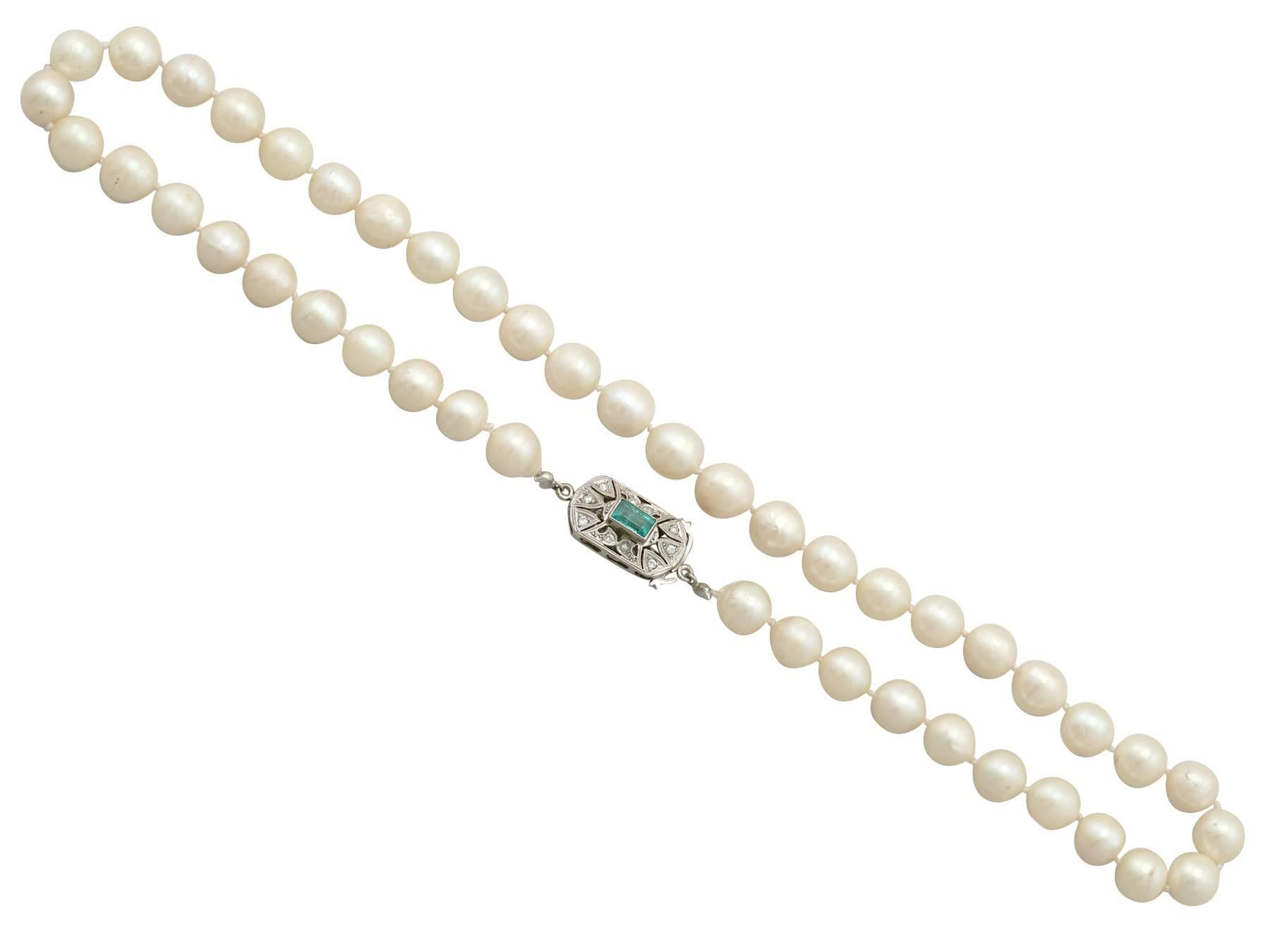 An impressive cultured pearl and 0.70 carat emerald, 0.10 carat diamond and 9 karat white gold single strand necklace; part of our diverse vintage jewelry collections

This fine and impressive single strand cultured pearl necklace consists of