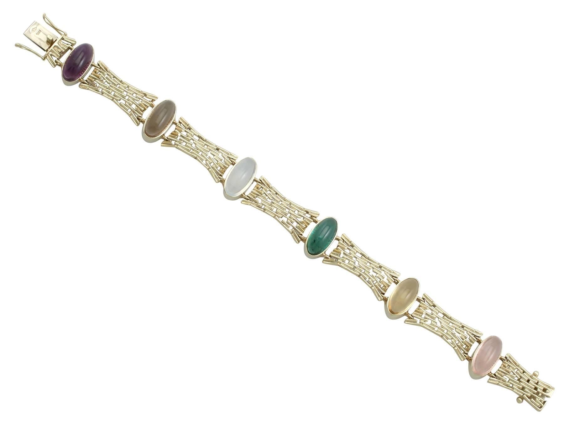 An impressive 15.27 carat amethyst, smoky quartz, moonstone, tourmaline, citrine, rose quartz and 14 karat yellow gold bracelet; part of our diverse gemstone jewellery collections. This fine and impressive multi gemstone bracelet has been crafted in
