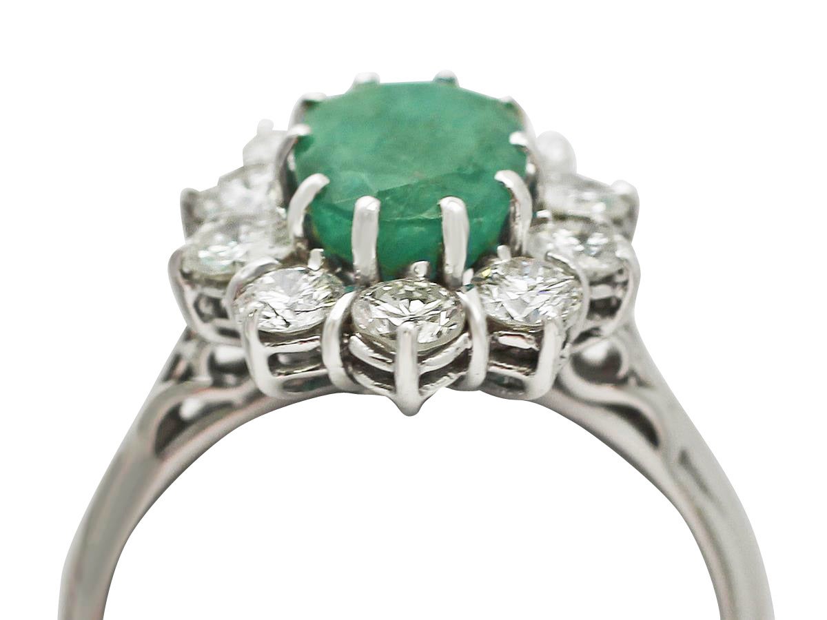 A fine and impressive vintage 2.09 carat natural emerald and 1.32 carat diamond, 18 karat white gold cluster ring; an addition to our vintage jewelry and estate jewelry collections

This impressive vintage emerald dress ring has been crafted in 18k
