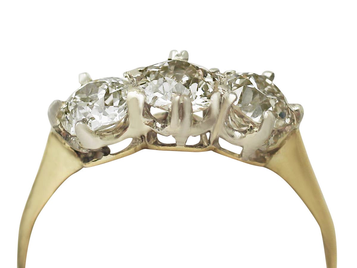 A fine and impressive antique 1.56 carat diamond three stone ring displayed in a vintage 18 karat yellow gold, platinum set setting; part of our diverse diamond jewelry and estate jewelry collections

This impressive Old European cut diamond ring