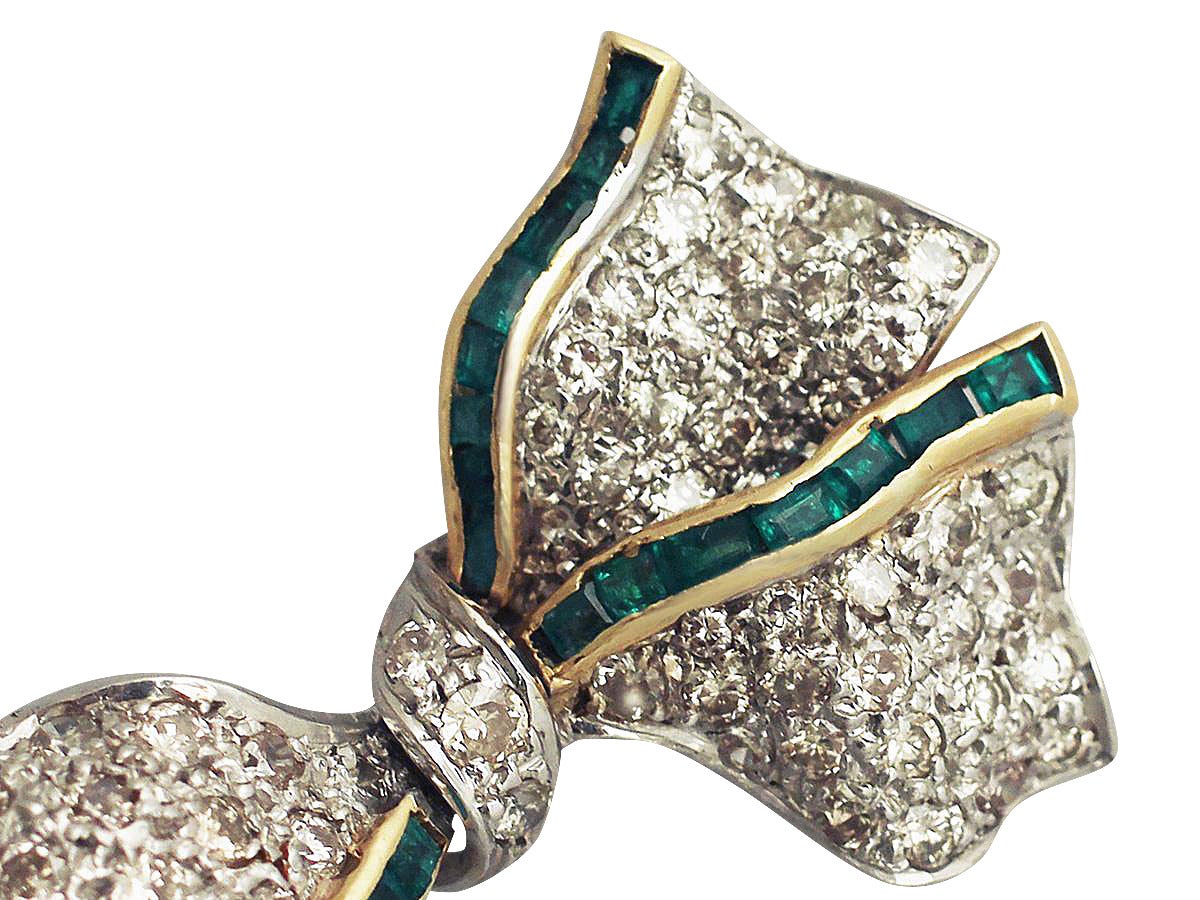 A fine and impressive 1.31 carat diamond and 0.52 carat emerald, 18 karat white gold, 18 karat yellow gold set bow brooch; part of our vintage jewelry/estate jewelry collections

This impressive diamond bow brooch has been crafted in the form of a