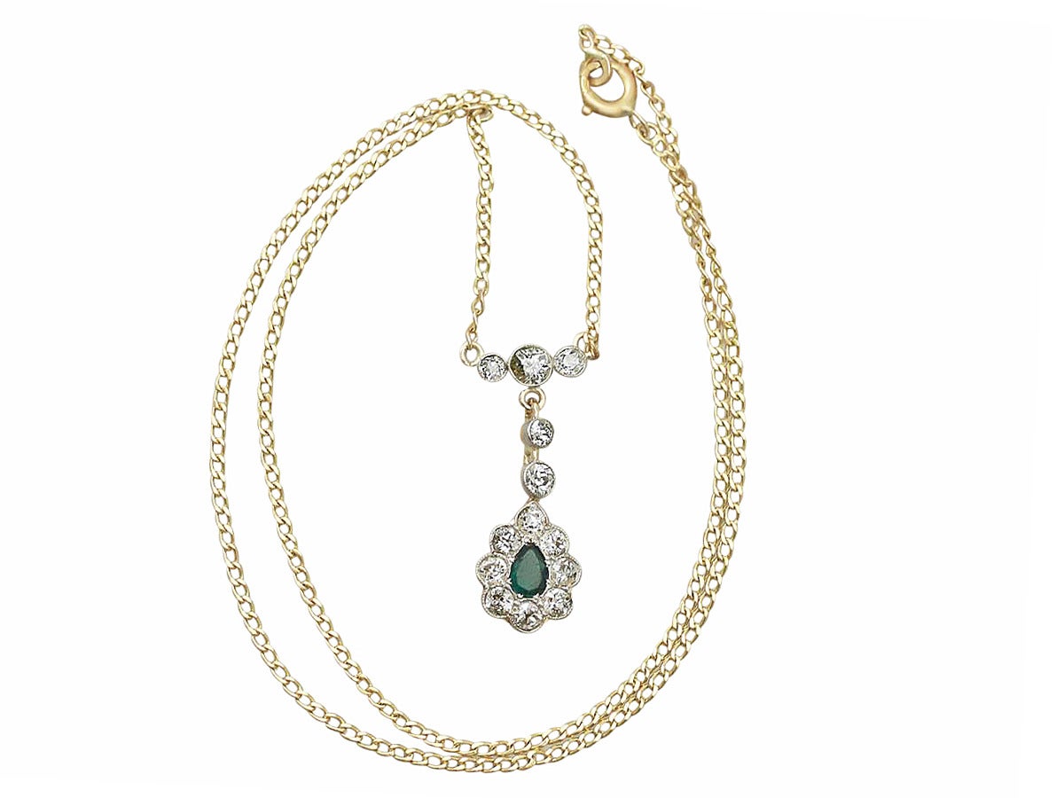 A fine and impressive antique 0.20 carat natural emerald and 0.82 carat diamond, 18 karat yellow gold, platinum set pendant; part of our antique jewelry and estate jewelry collections.

This stunning emerald and diamond pendant has been crafted in