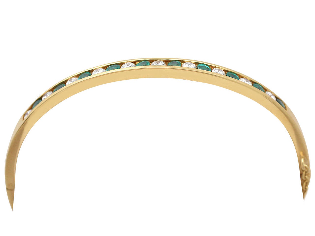 A fine and impressive 0.70 carat diamond and 0.55 carat natural emerald and 18 karat yellow gold bangle; part of our contemporary jewelry and jewelry collections

This impressive contemporary emerald and diamond bangle has been crafted in 18k yellow